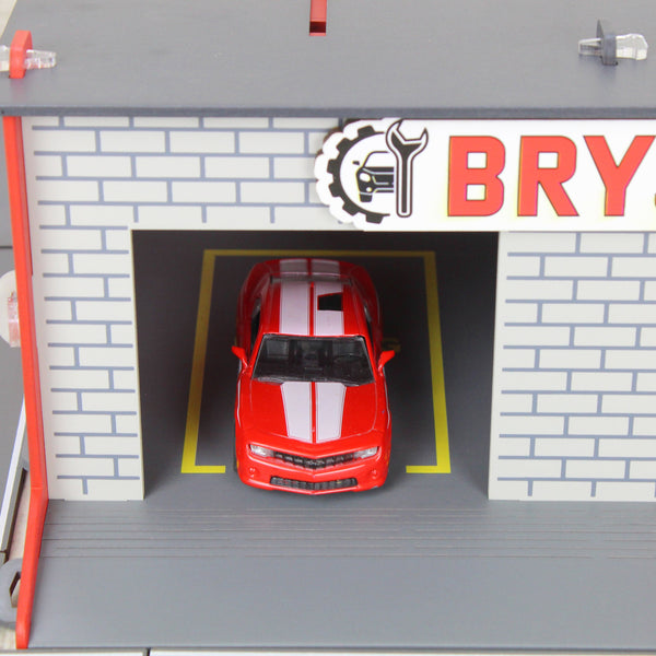 Toy garage with sectiona roll-up doors and garage door opener, toy car storage, toy car service station