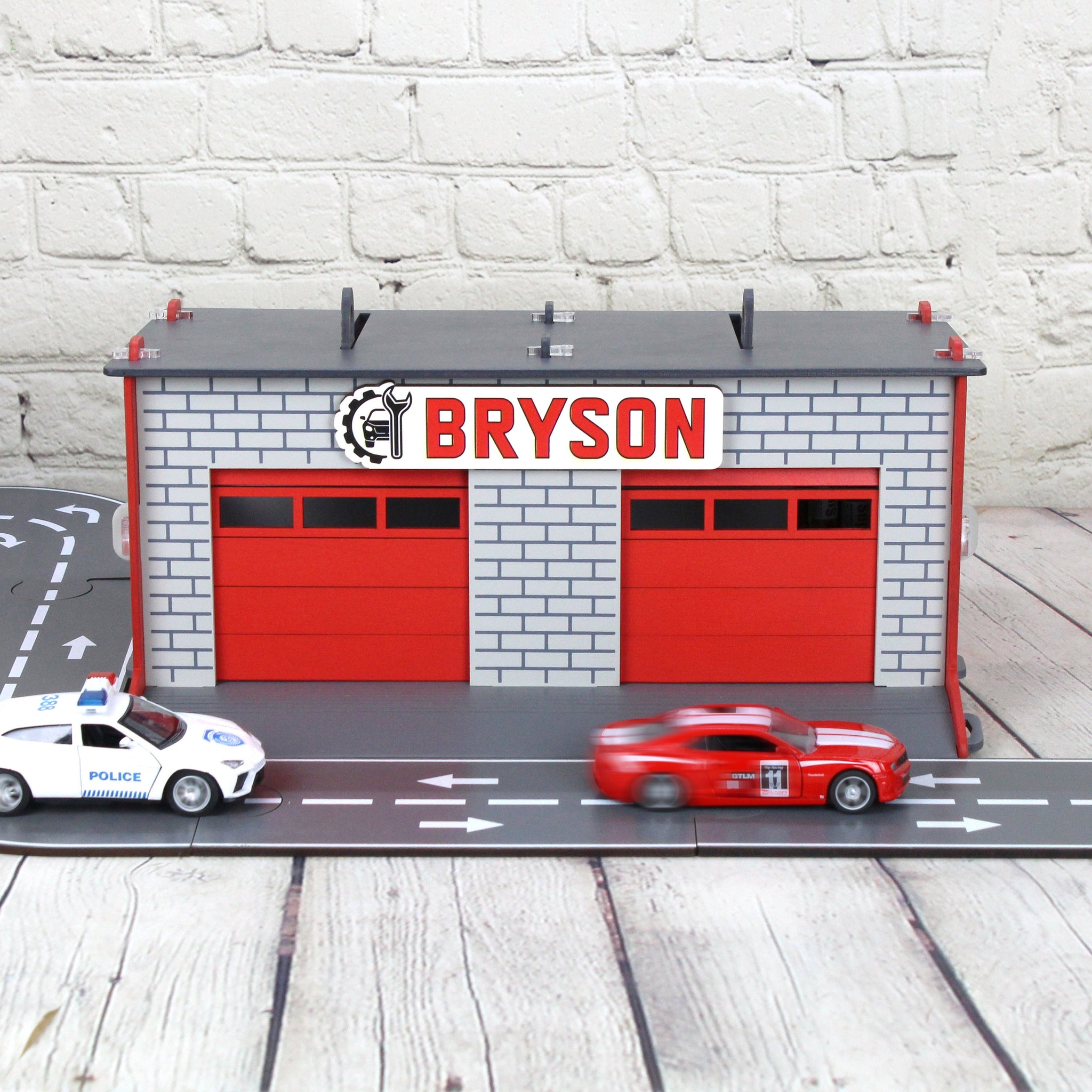 Toy garage with sectiona roll-up doors and garage door opener, toy car storage, toy car service station